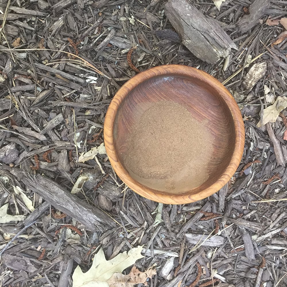 Rhodiola Root Powder A wooden bowl filled with fine, wild-harvested rhodiola root powder, representing its natural origins.